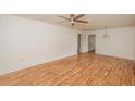 Bright living room featuring sleek hardwood floors, a ceiling fan, and freshly painted white walls at 601 N Franklin St, Plant City, FL 33563