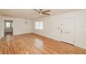 Bright living room featuring sleek hardwood floors, a ceiling fan, and a freshly painted white door at 601 N Franklin St, Plant City, FL 33563