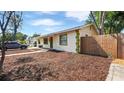Charming single-story home featuring freshly mulched landscaping, decorative trim and a well-maintained wooden fence at 6325 9Th S Ave, Gulfport, FL 33707