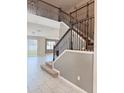 Bright entryway featuring tile floors, stairs, and an elegant wrought iron railing at 6325 Yellow Buckeye Dr, Riverview, FL 33578