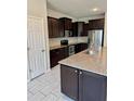 Modern kitchen featuring dark wood cabinets, granite countertops, and stainless steel appliances at 6325 Yellow Buckeye Dr, Riverview, FL 33578