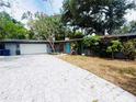 Charming single-story home with a brick driveway, lush landscaping, and light blue front door at 6429 Gulfport Blvd. South Blvd, South Pasadena, FL 33707