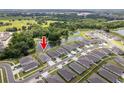 Aerial view of a neighborhood, showcasing the home's location on a pond with lush green surroundings at 7154 Steer Blade Dr, Zephyrhills, FL 33541