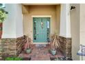 Beautiful front door with brick pillars, a wreath, and lovely potted plants on a brick porch at 7423 Sungold Meadow Ct, Apollo Beach, FL 33572