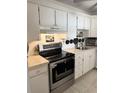 Bright kitchen featuring stainless steel appliances, white cabinets, and ample counter space for cooking and storage at 7465 Bay Island S Dr # 312, South Pasadena, FL 33707