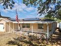 Inviting single-story home with a cozy front porch, solar panels and American flag at 8039 83Rd N St, Seminole, FL 33777