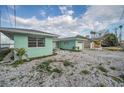 Charming turquoise home with a spacious gravel driveway and well-maintained landscaping at 94 Devon Dr, Clearwater Beach, FL 33767