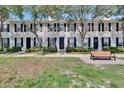 Exterior view of townhomes with landscaped lawns and a welcoming bench at 9506 Harpender Way, Tampa, FL 33626