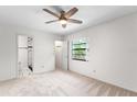 Bright bedroom features ceiling fan, neutral carpet, and ensuite bathroom with tiled shower at 9812 N Pawnee Ave, Tampa, FL 33617