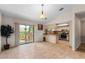 Open floorplan kitchen boasts stainless steel appliances, breakfast bar, and sliding door access to the deck at 9812 N Pawnee Ave, Tampa, FL 33617