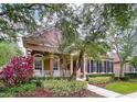 Charming two-story home featuring a cozy front porch, manicured landscaping, and a vibrant red front door at 10309 Marchmont Ct, Tampa, FL 33626