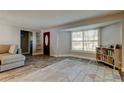 Bright living room with hardwood floors, large window, neutral walls and an interior door at 1041 Persimmon Dr, Palm Harbor, FL 34683