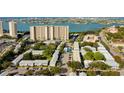 An aerial view of a neighborhood by the water with high-rise buildings and lush green landscaping at 1115 Rue Des Chateaux # 2B, South Pasadena, FL 33707