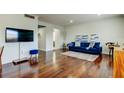 Bright living room with wood floors, a comfortable blue sofa, and stylish decor with TV at 1115 Rue Des Chateaux # 2B, South Pasadena, FL 33707