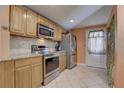 Modern kitchen with stainless steel appliances, tile backsplash, and ample cabinet space at 11665 Leisure W Ln, Largo, FL 33773