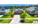 Aerial view of single-Gathering home with green lawn, mulch beds, and paved driveway in a residential neighborhood at 11707 Sunburst Marble Rd, Riverview, FL 33579
