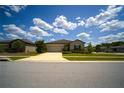 Inviting single-story residence displays lush landscaping and a driveway leading to an attached garage at 19047 Alfaro Loop, Spring Hill, FL 34610