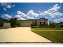 Inviting single-story home featuring an attached two-car garage and meticulously landscaped front yard at 19047 Alfaro Loop, Spring Hill, FL 34610