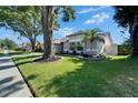 Well-manicured front yard featuring lush green grass, mature trees and tidy landscaping at 1910 Elk Spring Dr, Brandon, FL 33511