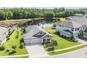 Aerial view of home showcasing lush landscaping, backyard pond, and three-car garage at 19837 Lonesome Pine Dr, Land O Lakes, FL 34638