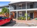 Two-story condo featuring gray siding, brick accents, black iron railings and lush landscaping at 200 Country Club Dr # 906, Largo, FL 33771