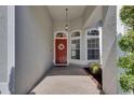 Inviting front entry with red door, decorative wreath, sidelight windows, and brick pavers at 2010 Rutherford Dr, Dover, FL 33527