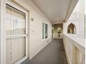 Condo 55's front door with storm door, small window and exterior walkway at 2221 Swedish Dr # 55, Clearwater, FL 33763