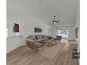 Staged living room featuring vaulted ceilings, modern fan, neutral furniture and light wood floors at 2405 Dakota Rock Dr, Ruskin, FL 33570