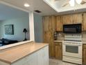 Charming kitchen featuring wooden cabinets, modern appliances, and a convenient breakfast bar overlooking the living area at 2567 Oakleaf Ln # 41B, Clearwater, FL 33763