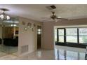 Spacious living room with tile flooring, mirrored wall, and an open view into the kitchen and sunroom at 2567 Oakleaf Ln # 41B, Clearwater, FL 33763
