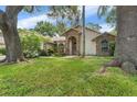 Charming single-story home featuring a brick archway, lush lawn, and mature trees at 3001 Folklore Dr, Valrico, FL 33596