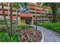 Building entrance featuring well-kept landscaping with colorful foliage at 3062 Eastland Blvd # 402, Clearwater, FL 33761