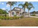 Elegant two-story house with manicured landscaping, tall palm trees and arched windows at 3434 St Ives Blvd, Spring Hill, FL 34609