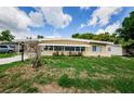 A cozy house with a lovely lawn and flowerbeds, enhanced by the sun-drenched sky, creates an inviting outdoor space at 406 Country Club Dr, Oldsmar, FL 34677