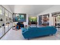 Bright living room with sleek furniture, white brick fireplace, and a view of outdoor grilling area through glass doors at 4610 Cypress S Way, St Petersburg, FL 33705
