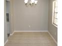 Unfurnished dining room highlighting tile flooring, neutral paint, chandelier and bright window at 4725 Joseph Ct # 233, Tampa, FL 33614