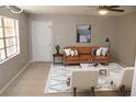 Stylized living room featuring modern furnishings, area rug, neutral paint, and tile flooring at 4725 Joseph Ct # 233, Tampa, FL 33614