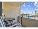 Relax on the balcony with a table and chairs, overlooking the pool and palm trees at 6009 Sea Ranch Dr # 107E, Hudson, FL 34667