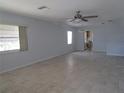 Expansive living room with neutral tile flooring, ceiling fan, and abundant natural light from multiple windows at 6015 19Th N St # 301, St Petersburg, FL 33714