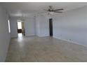 A spacious living room featuring neutral-toned tiled floors, a ceiling fan, and a doorway to the kitchen at 6015 19Th N St # 301, St Petersburg, FL 33714