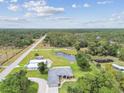 Stunning aerial view of a beautiful home, complete with a serene pond and lush landscaping, offering a peaceful retreat at 6080 Taneytown St, North Port, FL 34291