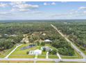 Expansive aerial view of a property with a private pond surrounded by lush greenery, offering tranquility and seclusion at 6080 Taneytown St, North Port, FL 34291