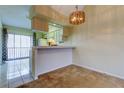 View of dining area featuring a breakfast bar and sliding doors to the outdoor patio at 6428 Gloria Dr # 21, New Port Richey, FL 34653