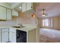 Functional kitchen adjacent to a cozy living area with a ceiling fan and natural light at 6428 Gloria Dr # 21, New Port Richey, FL 34653