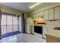 Bright kitchen with white appliances and cabinetry, flowing to an outdoor balcony at 6428 Gloria Dr # 21, New Port Richey, FL 34653