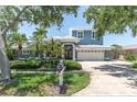 Beautiful two-story home featuring a well-manicured lawn, palm trees, and a two-car garage at 860 Harbor Is, Clearwater Beach, FL 33767