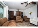 Comfortable living room with wood-look floors, plush seating, and a decorative ceiling fan at 8742 Narcissus Ave, Seminole, FL 33777