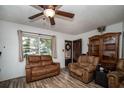 Cozy living room features wood-look floors, plush seating, and an abundance of natural light at 8742 Narcissus Ave, Seminole, FL 33777