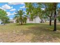 Side view of a single-story home with a palm tree, lawn and partial view of a screened patio at 9013 Nakoma Way, Weeki Wachee, FL 34613