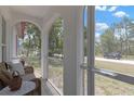 View from the screened-in porch overlooking a quiet neighborhood street with mature trees at 9013 Nakoma Way, Weeki Wachee, FL 34613